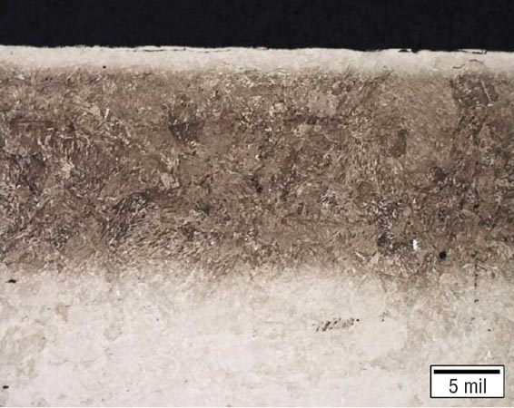 氮化合金組件的金相圖，具有均勻的滲氮層，深度約為0.40毫米（0.016英寸），并且沿表面明顯有淺白亮層。
